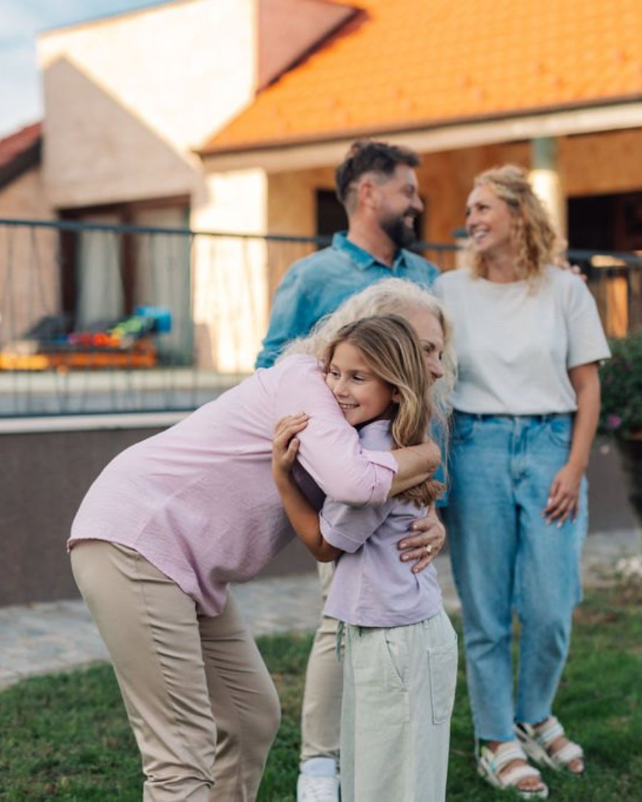 A multi-generational family gathering outside a suburban home